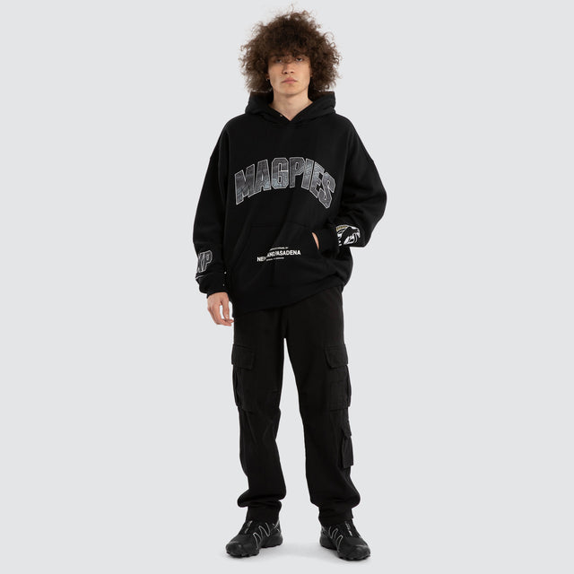 Model wears Ben Davis Collingwood Magpies AFL Box Fit Hoodie Jet Black Hoodies in Black - Image 7