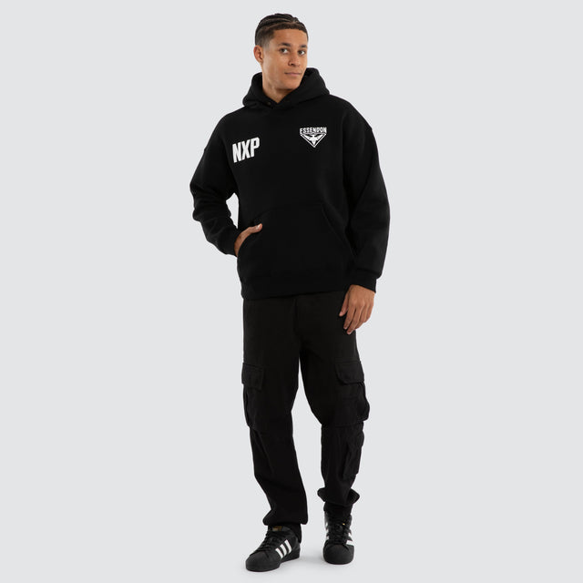 Model wears Essendon Bombers AFL Champions Box Hoodie Jet Black Hoodies in Black - Image 5