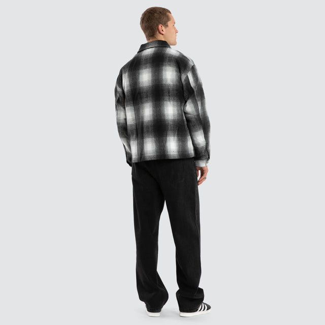 Model wears Rise Relaxed Jacket Black/White Check Jacket in Black - Image 4