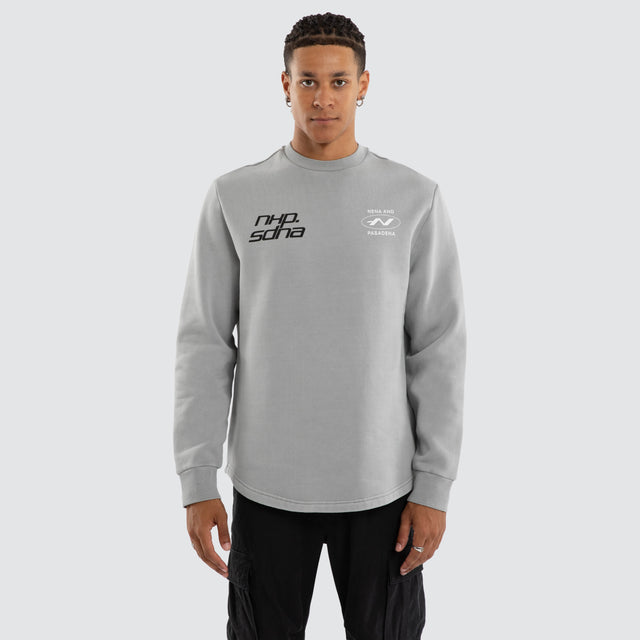 Model wears Independent Curved Sweater Pigment Ultimate Grey Jumpers in Grey - Image 1