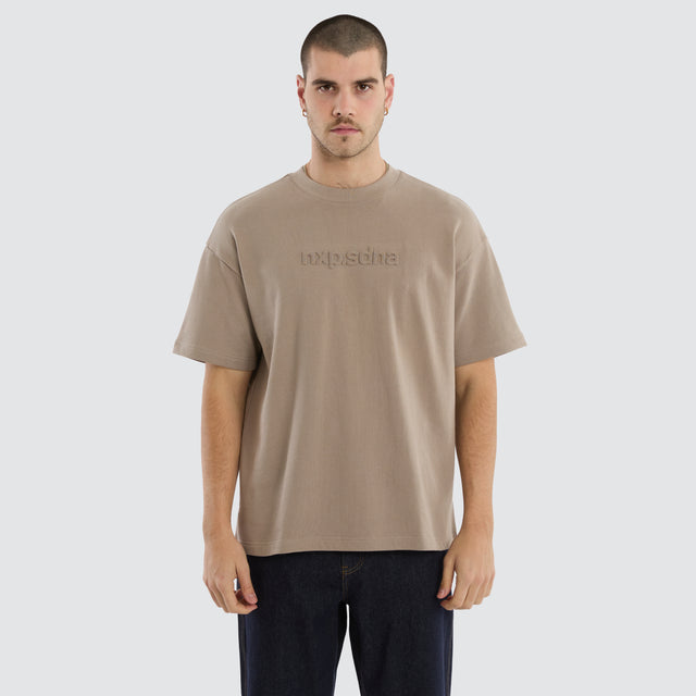 Model wears Overcome Raptor Tee Cinder T-shirt in brown - Image 1