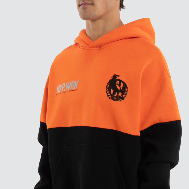 Model wears Collingwood Magpies Block Hoodie Orange Black Hoodies in Orange - Image 4