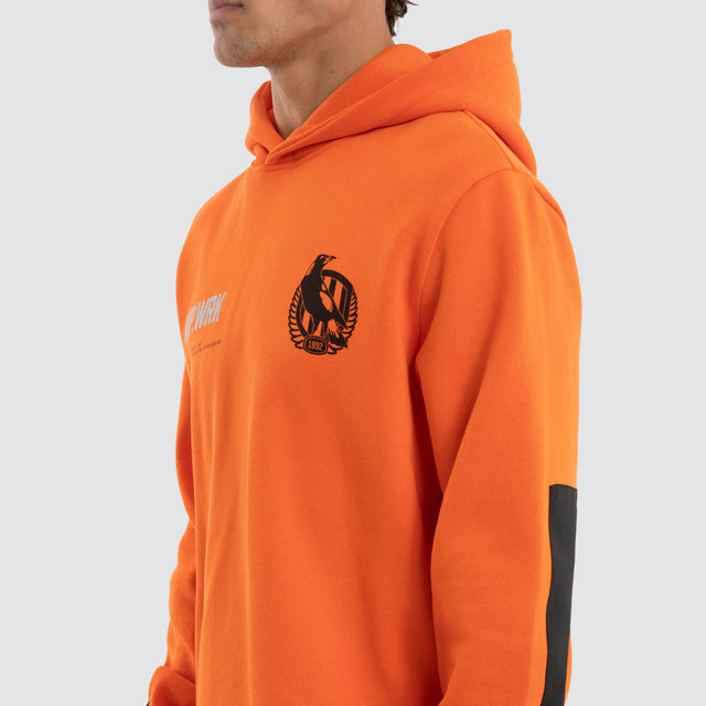 Model wears Collingwood Magpies Admission Hoodie Orange Hoodies in Orange - Image 3