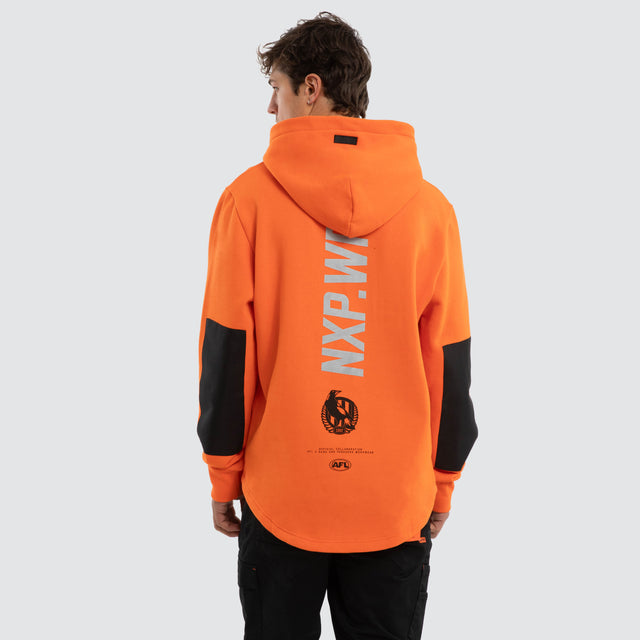Model wears Collingwood Magpies Admission Hoodie Orange Hoodies in Orange - Image 2