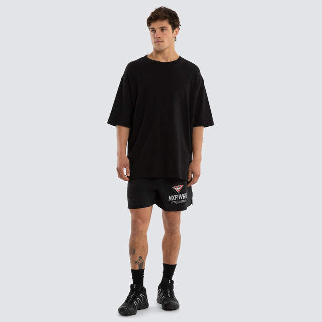 Model wears Essendon Bombers Contract Short Jet Black Shorts in Black - Image 4