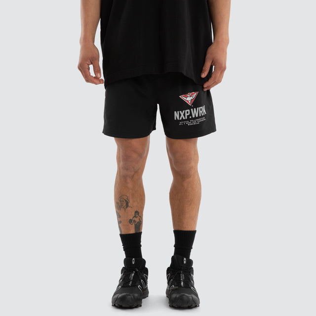 Model wears Essendon Bombers Contract Short Jet Black Shorts in Black - Image 1